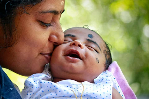 photo of a baby smiling with mother