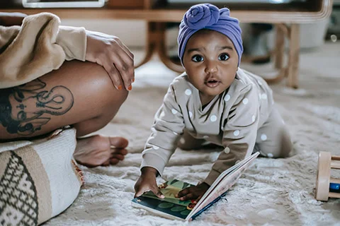 photo of a baby with book